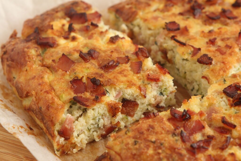 Bacon and zucchini slice fresh from the oven, golden on top with melted cheese and crumbled feta