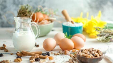 Adapt a recipe for food intolerances — eggs, nuts, flour, milk, and cinnamon on a bench.
